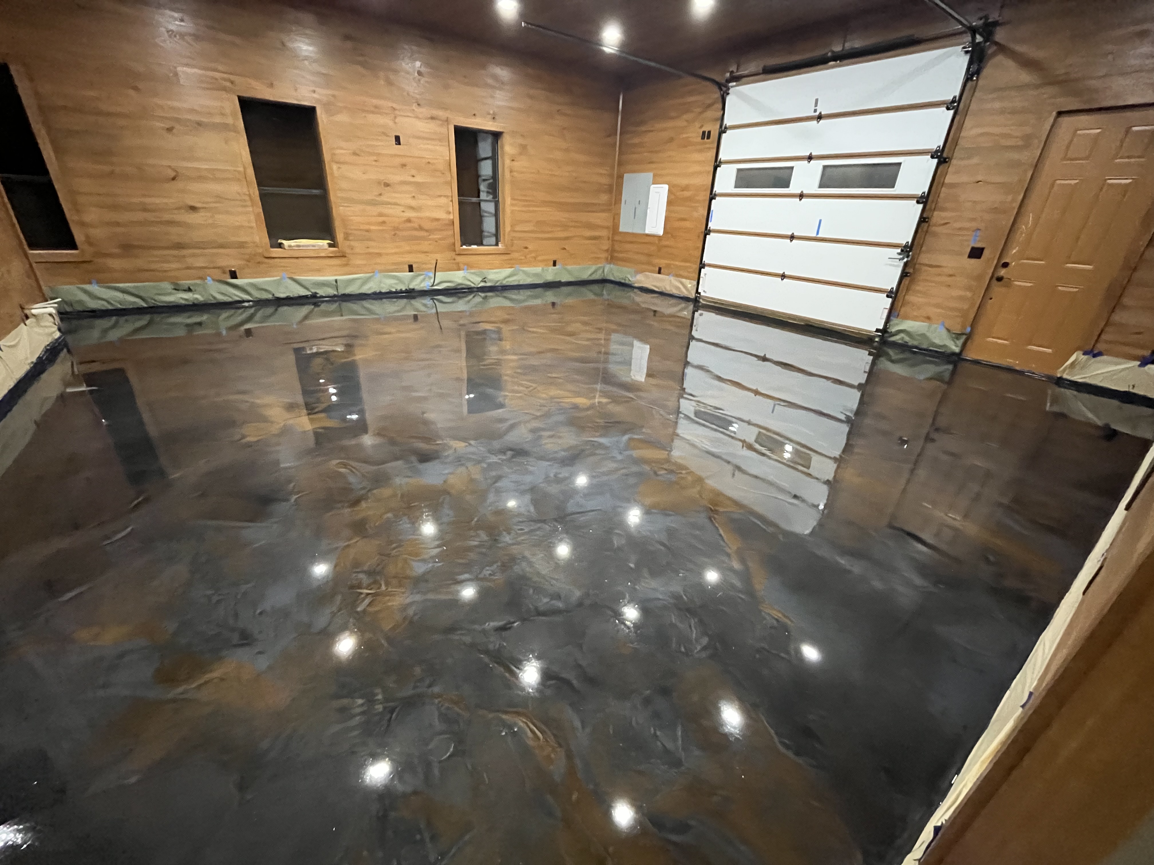 Inside a Garage With a Stylish Black Floor and Rustic Wood Walls